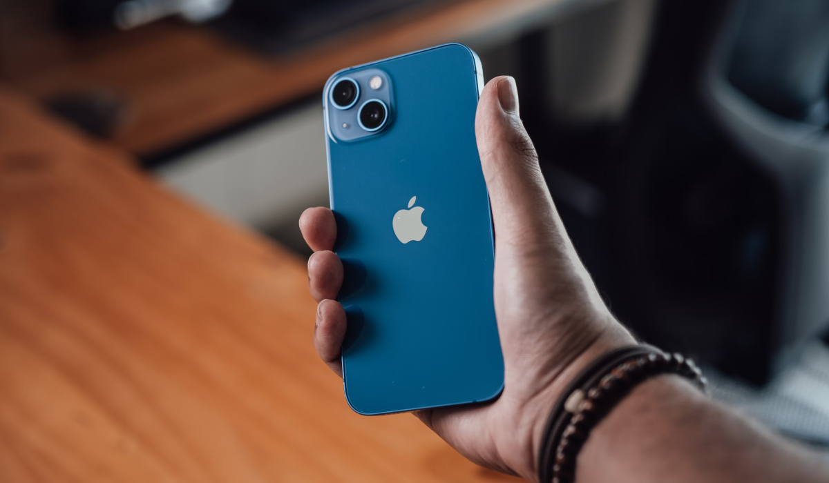 Photo d'un iPhone 13 dans les mains de son utilisateur