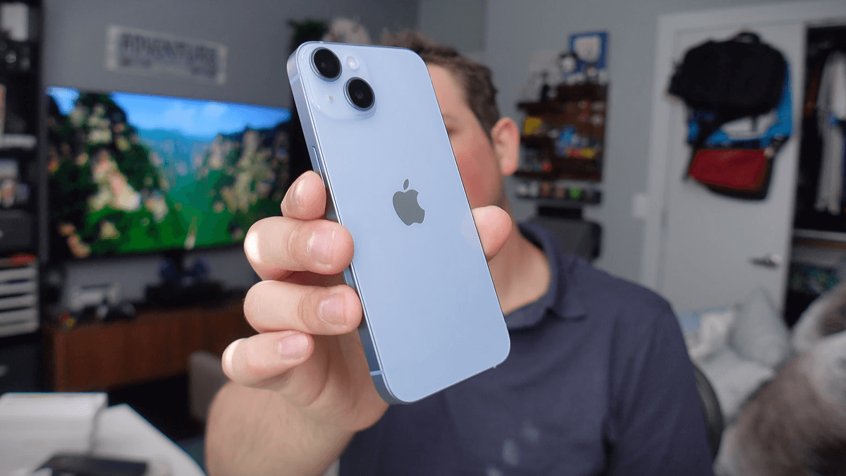 iPhone 14 tendu fièrement vers l'objectif par un expert